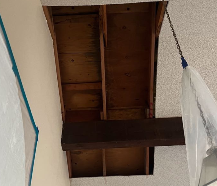 A water-damaged ceiling with a part of it taken out and is empty inside
