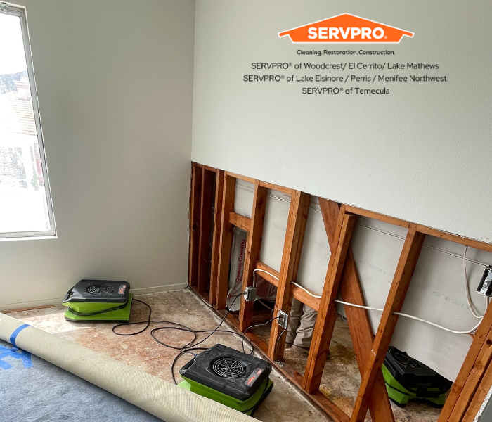 SERVPRO Air movers drying a water damaged living room and wall