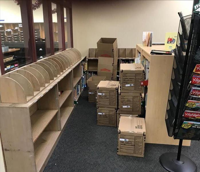library books and shelf being packed up from water