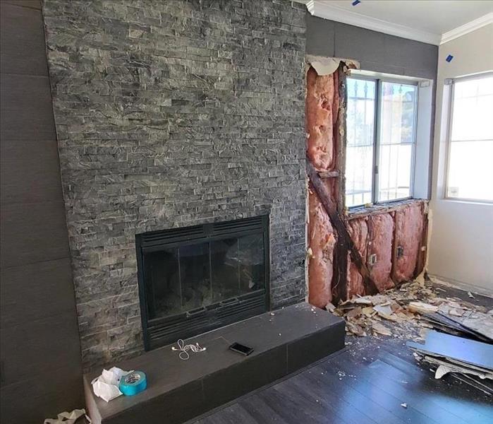 living room with white walls, fire place with mantle pictures on walls 